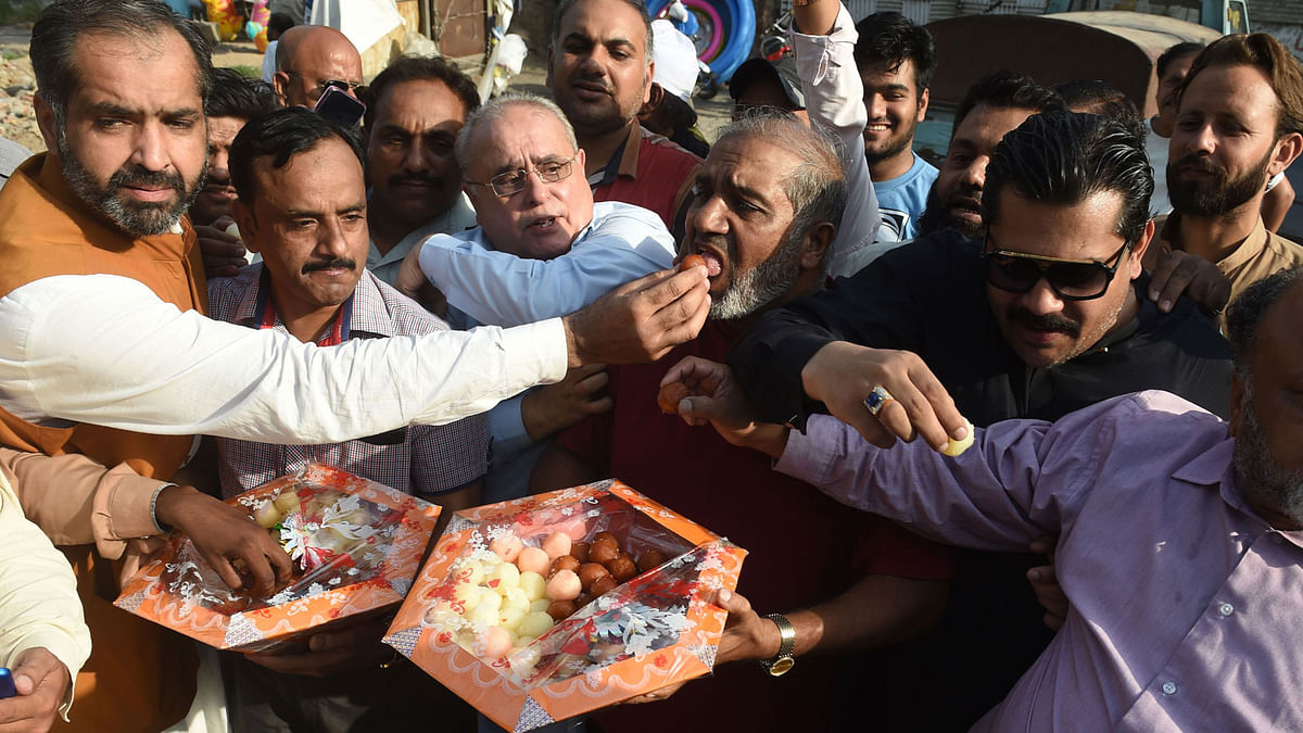 Pakistani supporters of ousted prime minister Nawaz Sharif eat sweets as they celebrate a court verdict in Lahore on 19 September, 2018. A Pakistani court on September 19 ordered the release of former Prime Minister Nawaz Sharif and his daughter, suspending their prison sentences pending an appeal hearing. Photo: AFP