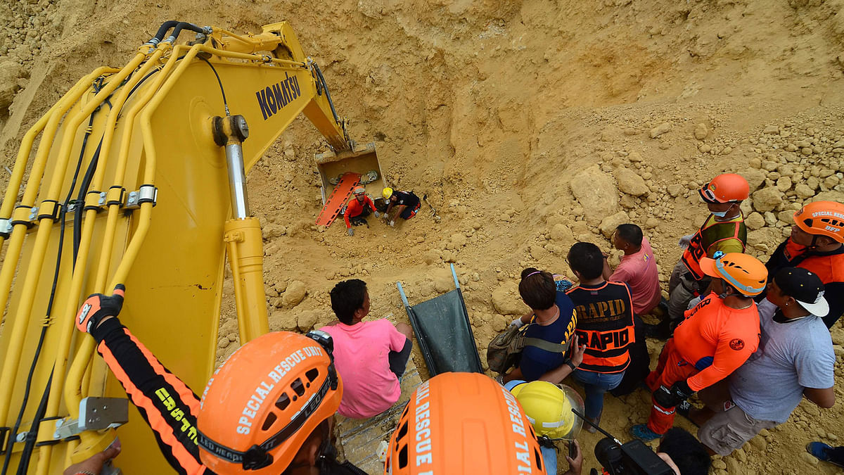 This photo taken on 20 September 2018 shows rescue workers using a backhoe as they retrieve a body at the landslide site in Naga City on the popular tourist island of Cebu. Photo: AFP