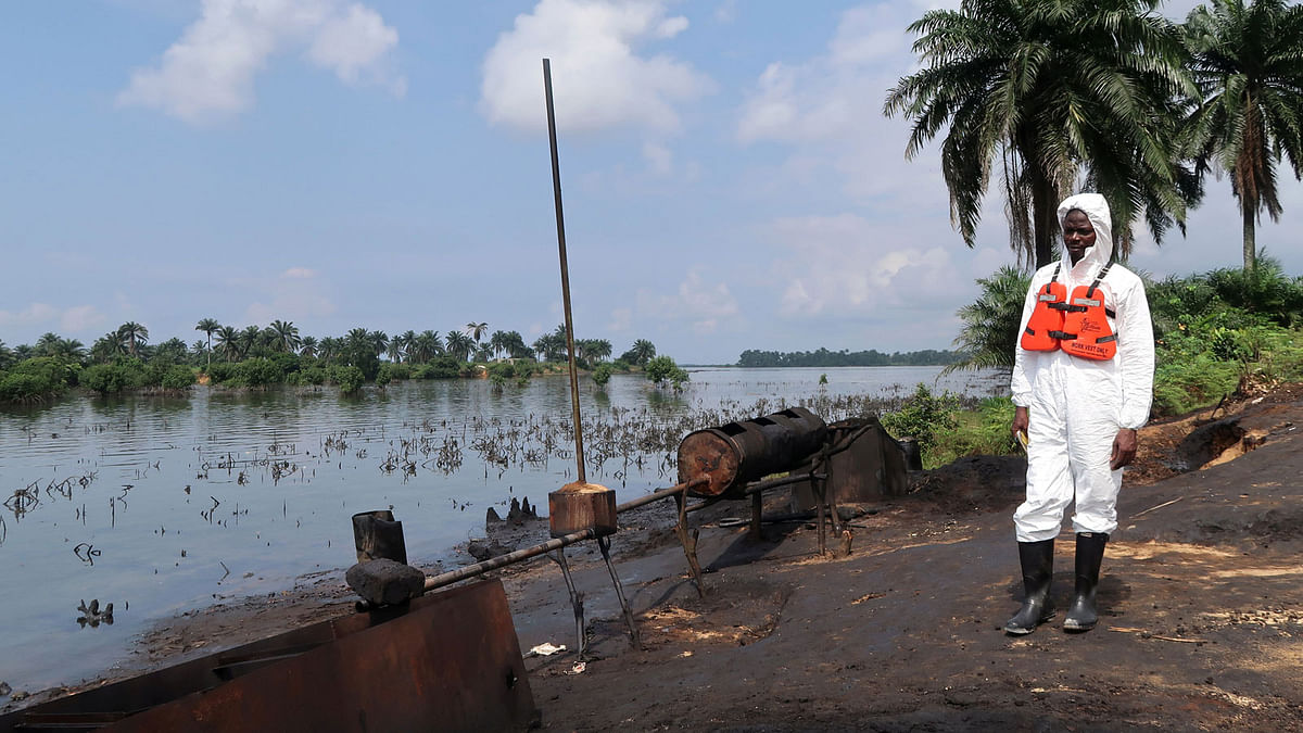 A member of the joint task force, part of the Bodo oil spill clean-up operation, stands near the site of an illegal refinery near the village of Bodo in the Niger Delta. Photo: Reuters