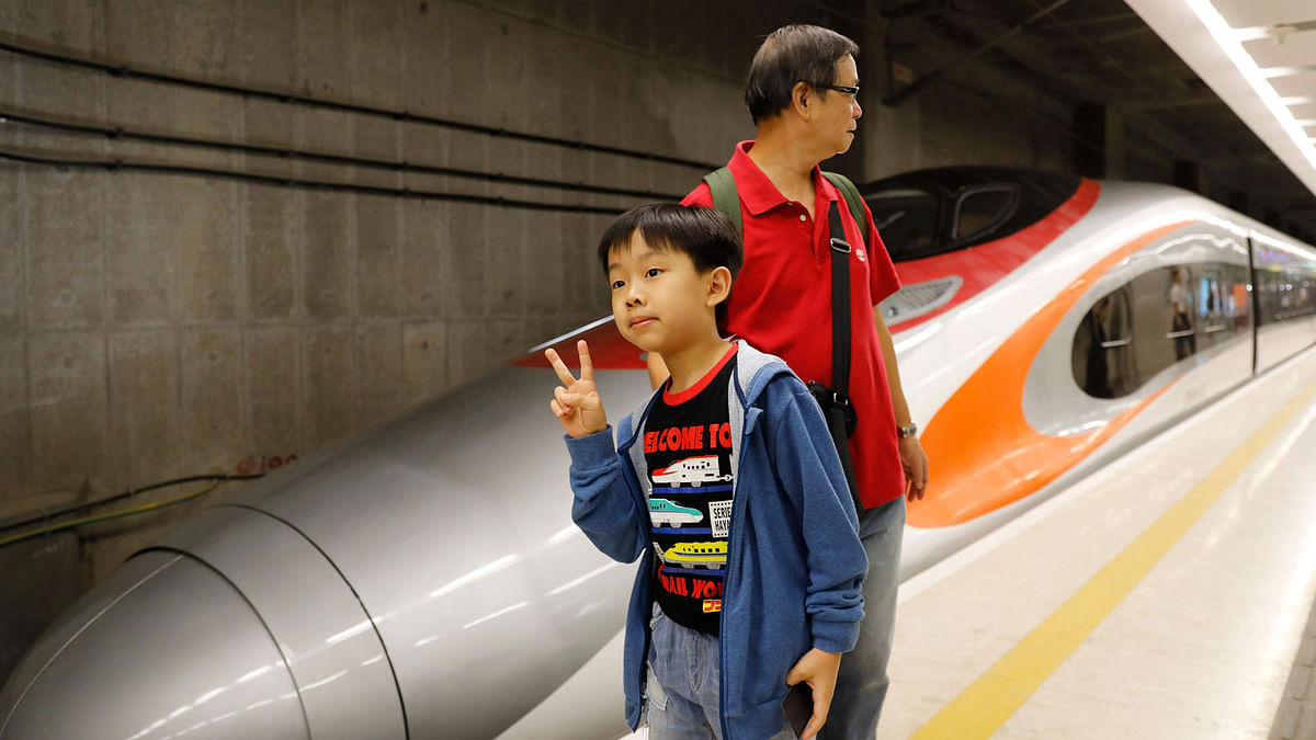 A boy poses with a Guangzhou-Shenzhen-Hong Kong Express Rail train at West Kowloon Terminus on the first day of rail service in Hong Kong on 23 September 2018. Photo: AFP