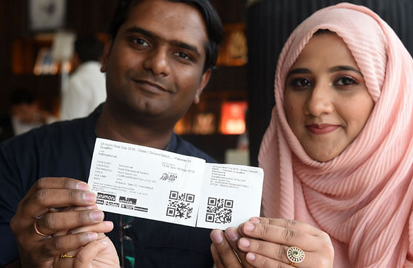 This photograph taken on September 19, 2018 shows Indian cricket fans Kassim Vakkil and Ghazala holding up ticket of the Asia Cup cricket match between Pakistan and India in Dubai. While India and Pakistan`s fierce cricket rivalry has been on display at the Asian Cup in the United Arab Emirates, some families in the country have divided loyalties. AFP