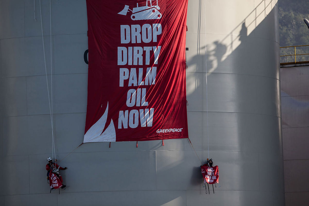 This handout picture taken on 25 September 2018 and released by Greenpeace Southeasia shows Greenpeace activists unfurling a banner reading `Drop Dirty Palm Oil Now` at the Wilmar International refinery in Bitung, North Sulawesi. Photo: AFP