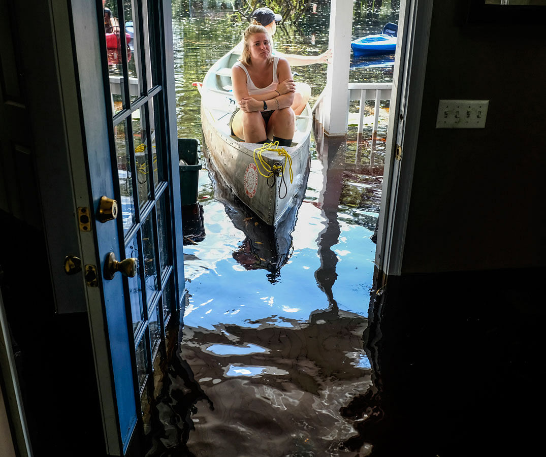 Maura Walbourne sits in the front of a canoe looking in at her flooded Long Avenue home as David Covington wades through the wreckage in Conway, SC on 23 September. Photo: AP