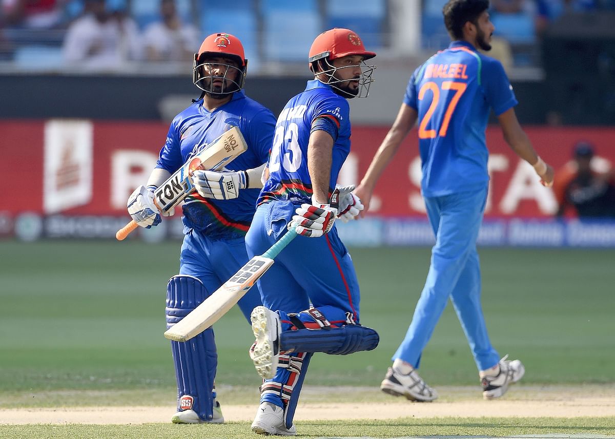 Afghan batsman Mohammad Shahzad (L) and Javed Ahmadi runs between the wickets during the one day international (ODI) Asia Cup cricket match against India at the Dubai International Cricket Stadium in Dubai on 25 September 2018. Photo: AFP