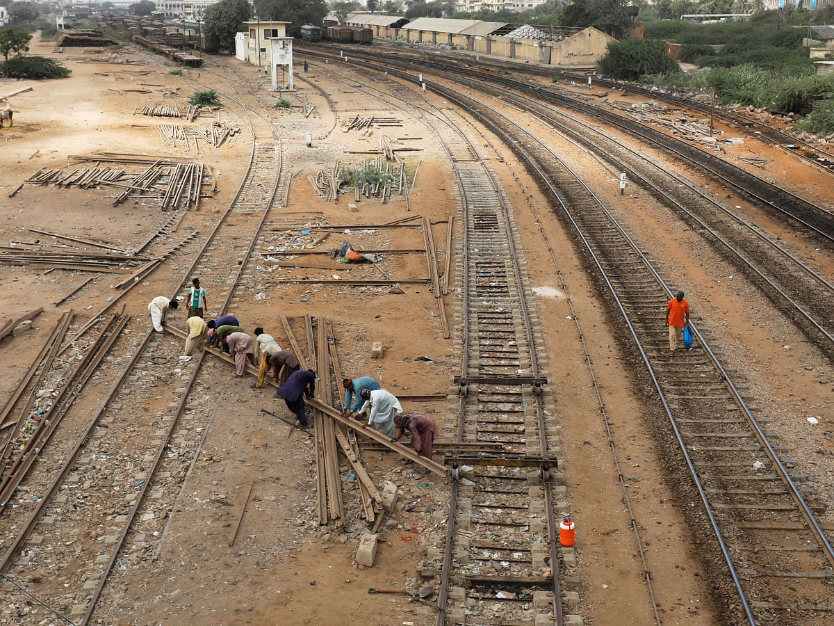 Labourers from the Pakistan Railways are seen working on railway tracks along City Station in Karachi. Photo: Reuters