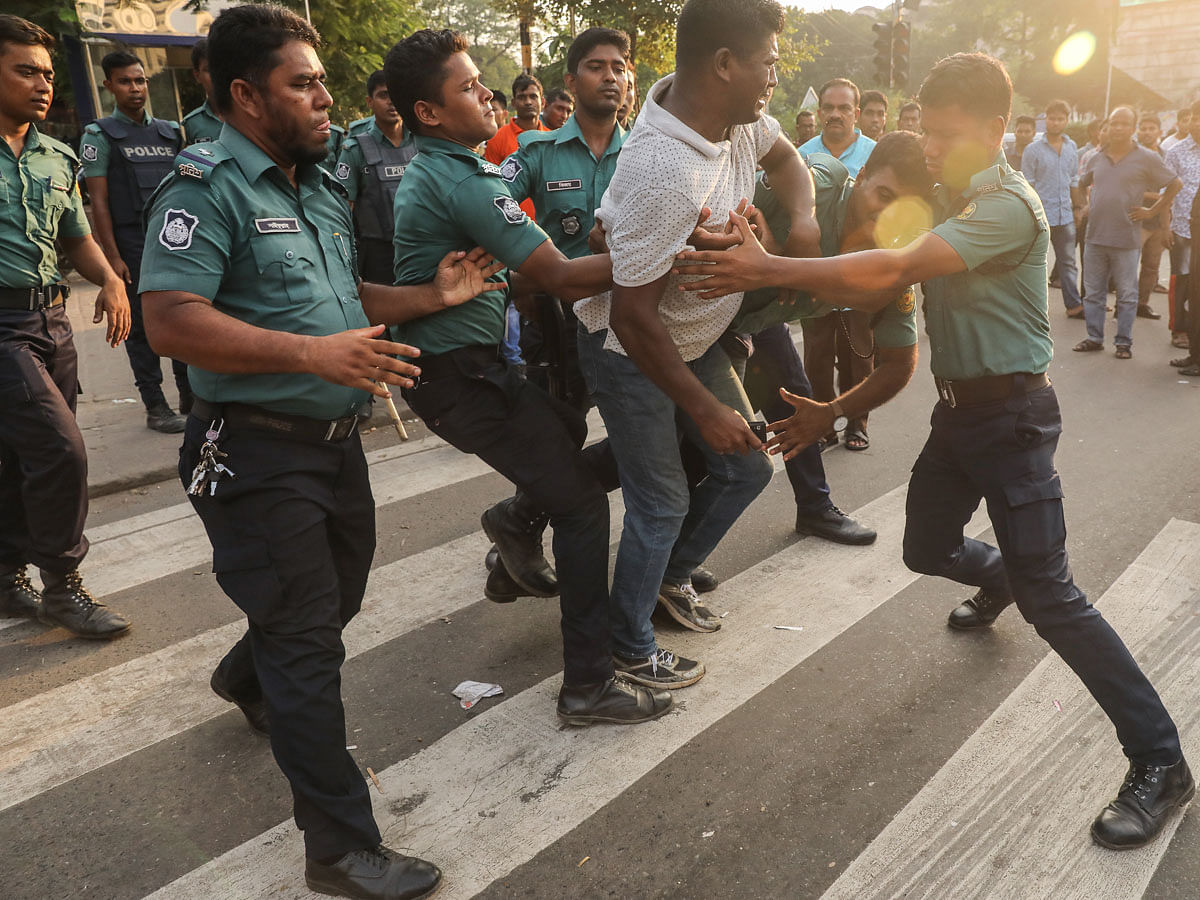 Police detains a youth from Shahbagh intersection in Dhaka near the BNP pubic rally on 30 September. Photo: Dipu Malakar