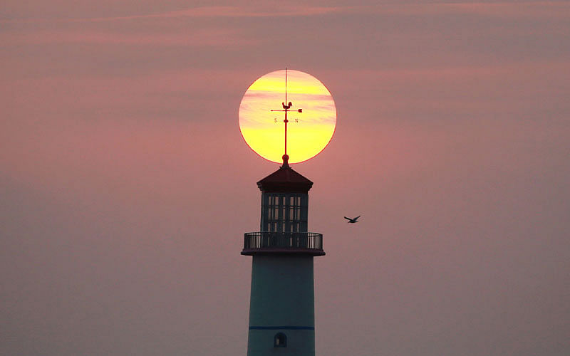The sun sets behind a lighthouse in Dalian, Liaoning province, China. A recent photo by Reuters