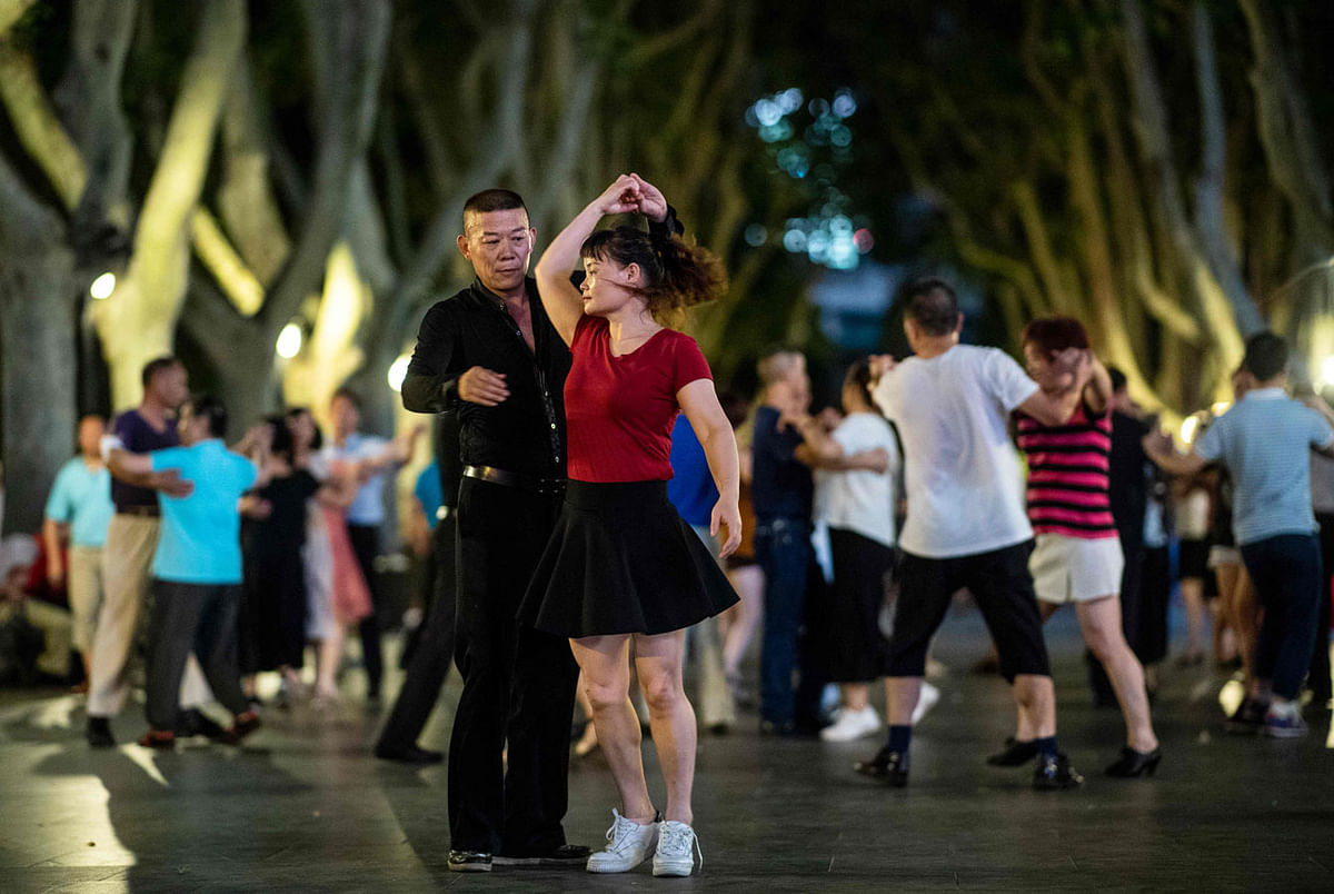 This picture taken on 29 August 2018 shows a couple dancing in a public park in Shanghai. In a sparkling white cap and oversized sunglasses, 55-year-old retiree Zhang Yongli and dozens of neighbours liven up a Shanghai park by doing the jitterbug, part of a public dance craze that has become China`s national pastime. Photo: AFP
