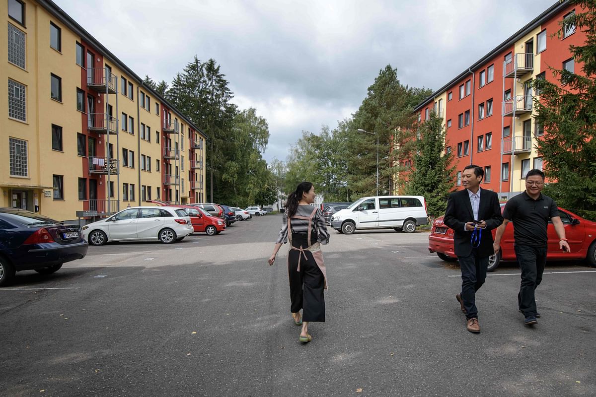 Inhabitants walk in the streets of the so-called `Oak Garden` residential complex, a former housing of the US Army, in the German western town of Hoppstaedten-Weiersbach on 7 September 2018. Photo: AFP