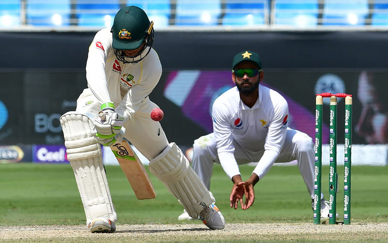 Australian cricketer Usman Khawaja (L) plays a shot during the fifth day of first Test cricket match in the series against Pakistan at the Dubai International Stadium in Dubai on 11 October 2018. Photo: AFP