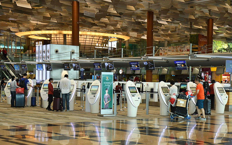Singapore Airlines passengers check-in at the automated booth at the international departure area of Changi International Airport in Singapore on 11 October 2018. Photo: AFP
