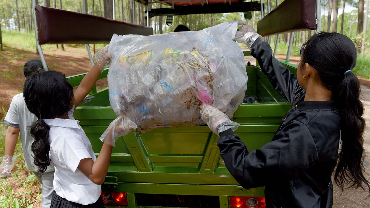 This photo taken on 1 October 2018 shows students of Coconut School collecting discarded plastic water bottles and other recyclable scraps at Kirirom national park in Kampong Speu province. Photo: AFP