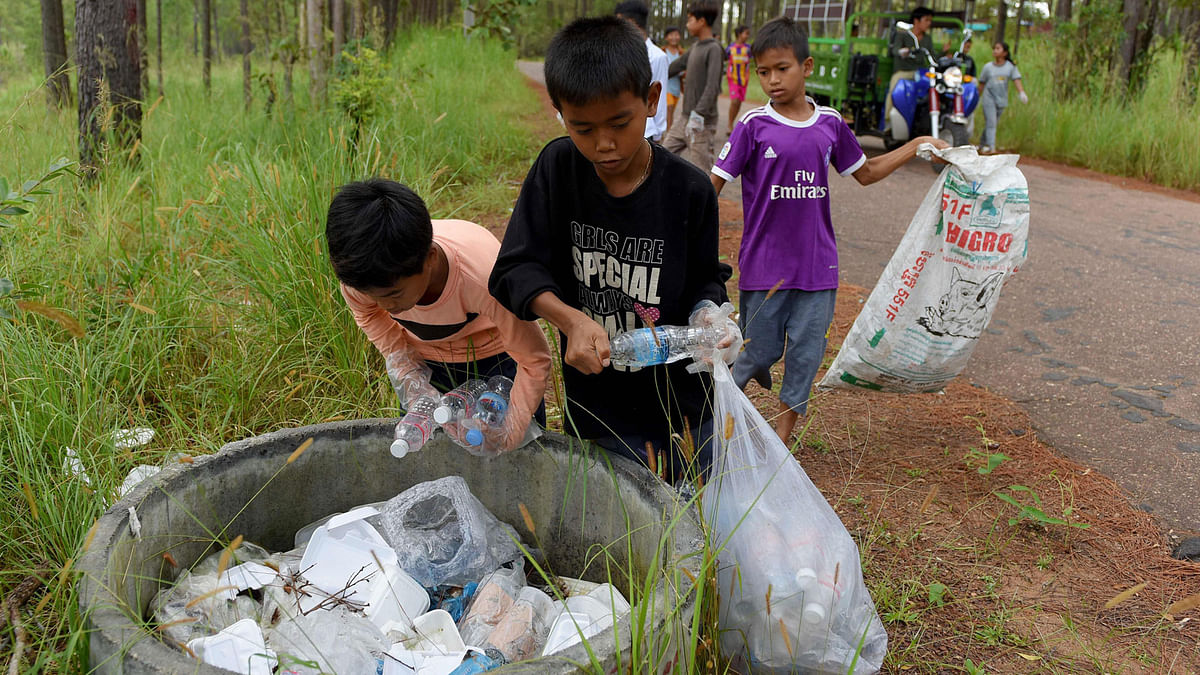 This photo taken on 1 October 2018 shows students of Coconut School collecting discarded plastic water bottles and other recyclable scraps at Kirirom national park in Kampong Speu province. Photo: AFP