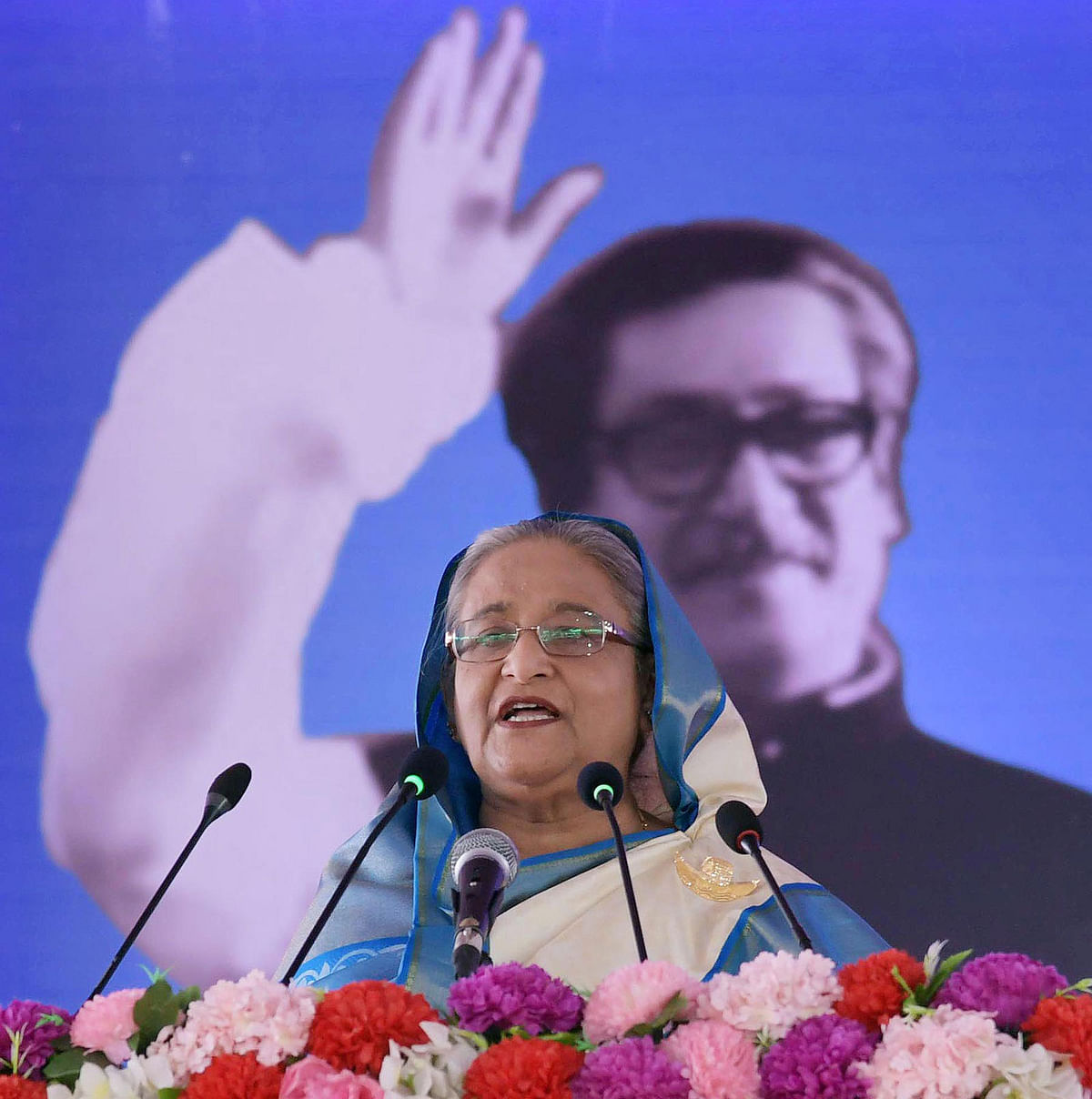 Prime minister Sheikh Hasina addresses a rally after unveiling the name plaque of the Padma multipurpose bridge, plaque of progress work on the 6.15-kilometre bridge on Mawa side, `Padma Bridge Rail Link Construction Project` and permanent river bank protection works adjacent to the main river in Munshiganj on Sunday. Photo: PID