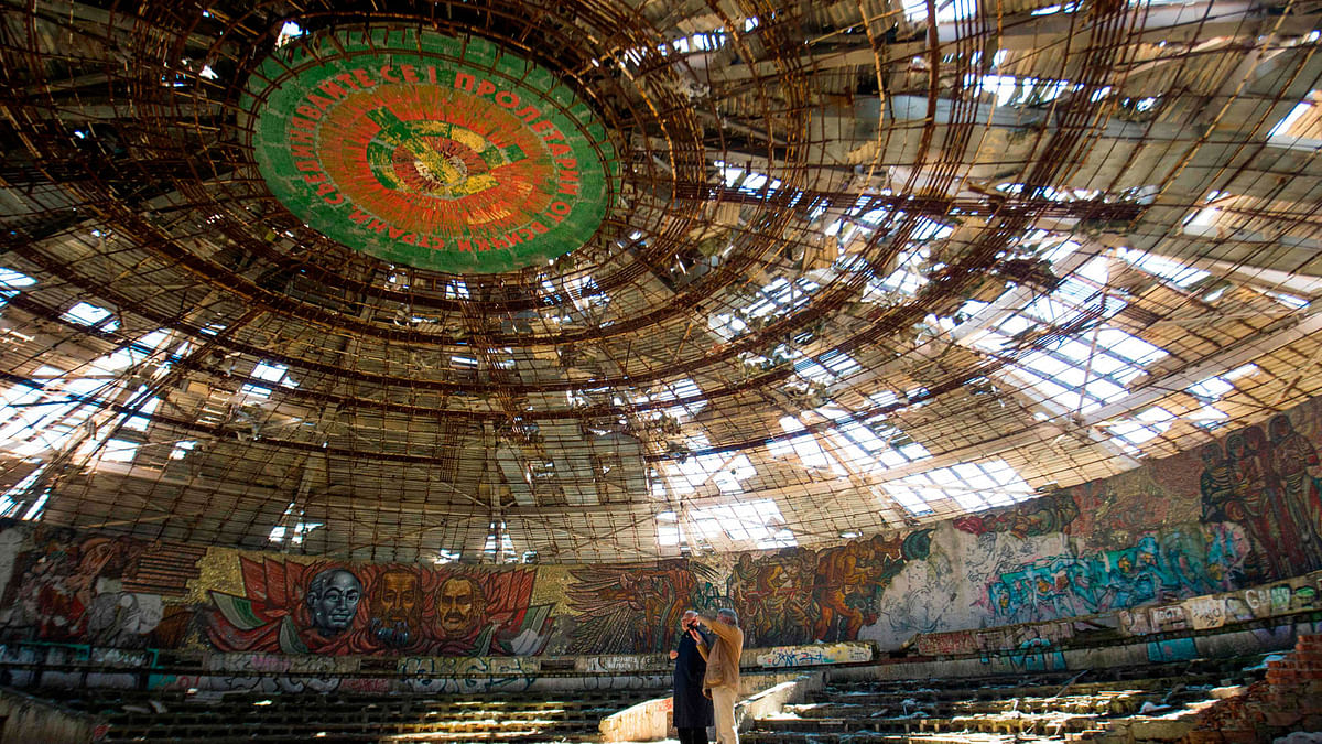 In this file photo taken on 27 September experts from Europa Nostra, a NGO for protection and celebration of Europe`s cultural and natural heritage inspect the crumbling oval skeleton of the House of the Bulgarian Communist Party on mount Buzludzha in central Bulgaria. Photo: AFP