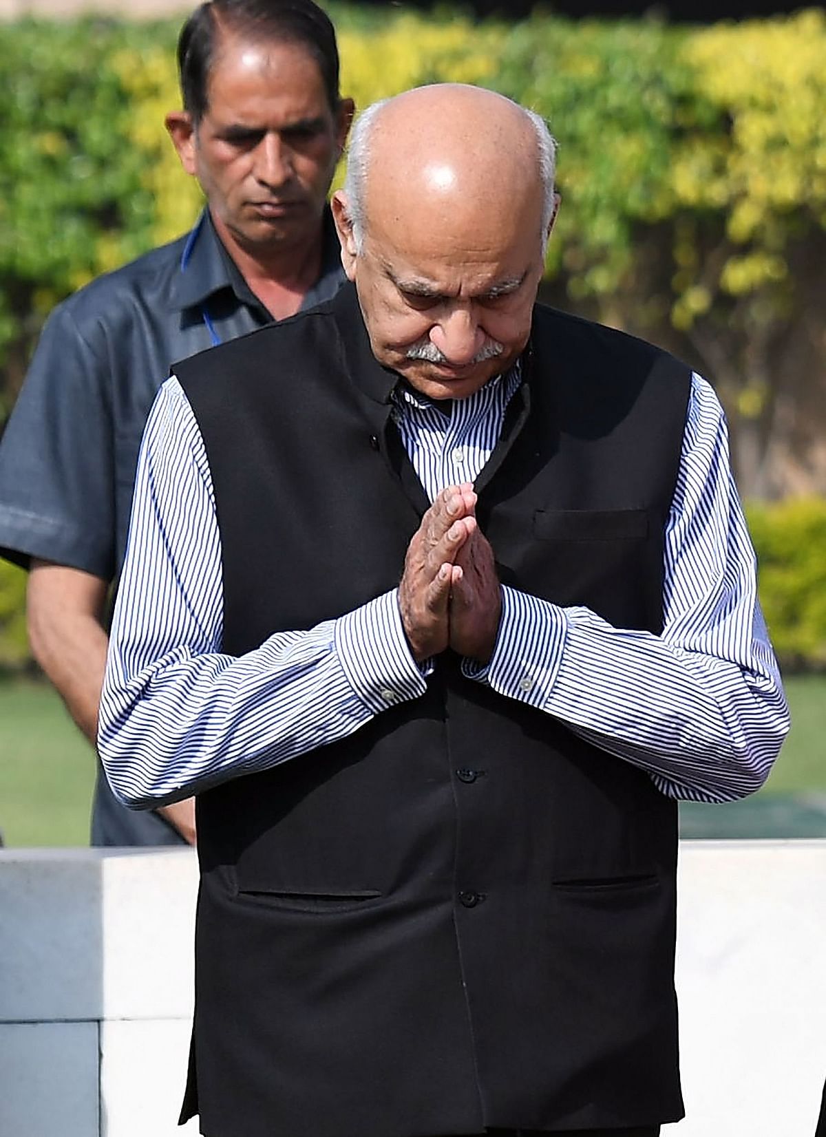 This photo taken on 10 March 2018, shows Indian Minister of State for External Affairs MJ Akbar offering prayers while accompanying French President Emmanuel Macron and his wife Brigitte Macron to their visit to Rajghat, memorial for Mahatama Gandhi in New Delhi. India`s belated #MeToo movement snowballed on 9 October after several female journalists accused a minister in Narendra Modi`s government of sexual harassment and a producer alleged she was raped by a veteran Bollywood actor. Women journalists took to Twitter to allege how MJ Akbar, a well-known former editor and now a junior foreign minister, conducted job interviews in fancy hotel rooms and made sexual advances when they were starting out in the media. -- Photo: AFP