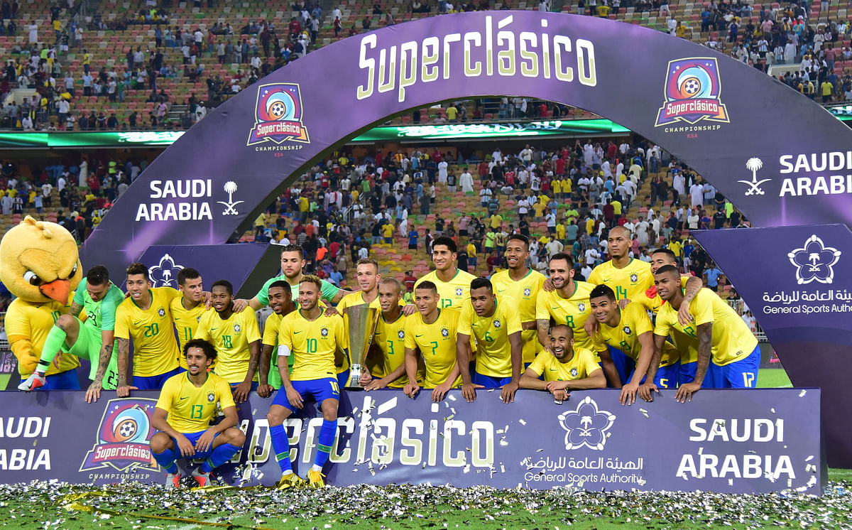 Brazil players pose for a photo with the trophy as they celebrate after the match. Reuters