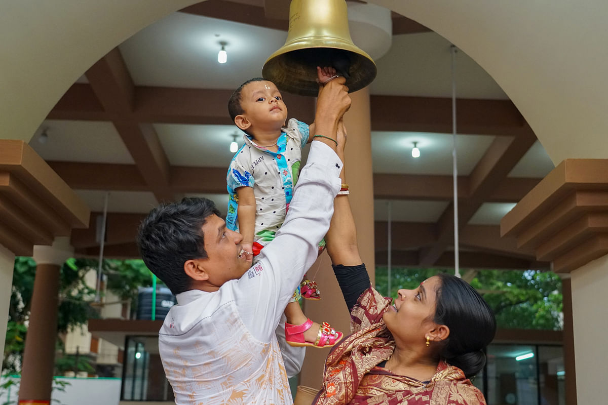 Parents try to make their child ring the bell at the temple of Dhakeshwari in Dhaka on 16 October, on Mahasaptami of Durga Puja. Photo: Sabrina Yesmin