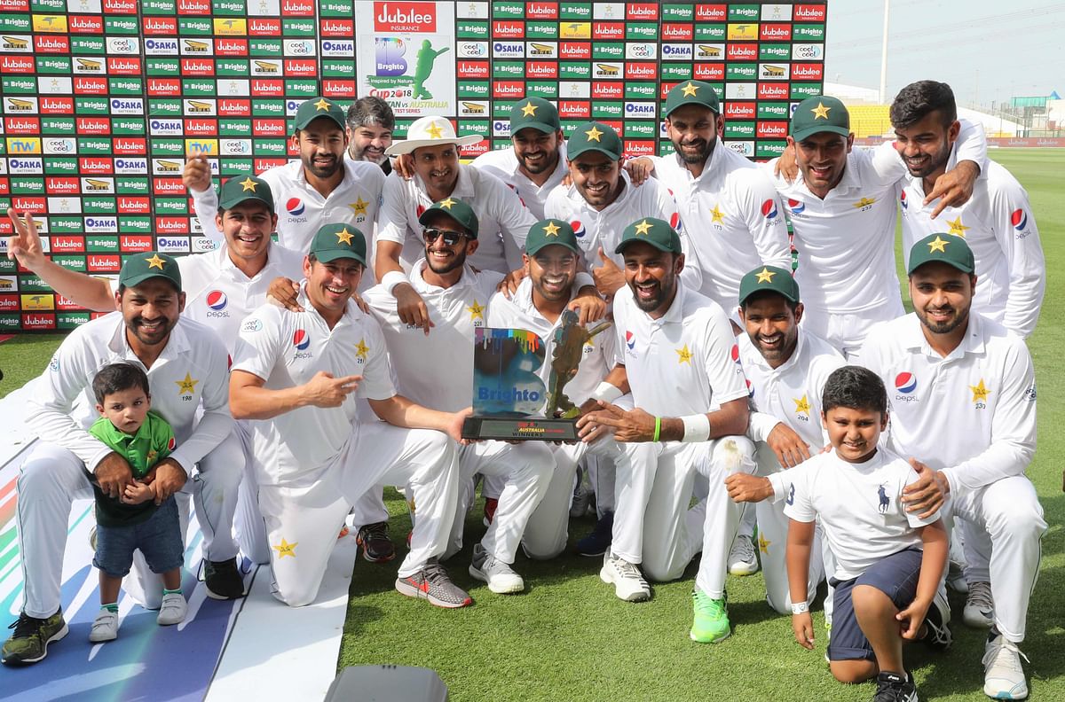 Pakistan`s cricket team celebrates at the end of day four of the second Test match between Australia and Pakistan at Sheikh Zayed stadium in Abu Dhabi on 19 October 2018. Photo: AFP