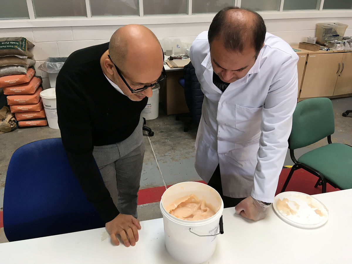Lancaster University researchers Professor Mohamed Saafi and Hasan Hasan look into a bucket containing carrot mixture to be added to concrete, in their laboratory in Lancaster, Britain on 2 October. Photo: Reuters