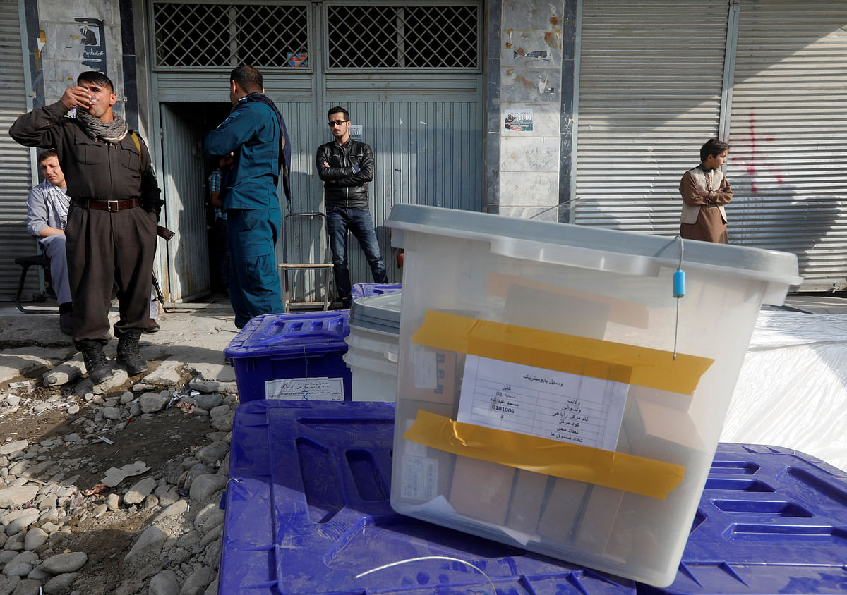 Afghan police officers stand guard while election commission workers prepare ballot boxes and election material at a polling station in Kabul, Afghanistan on 19 October. Photo: Reuters