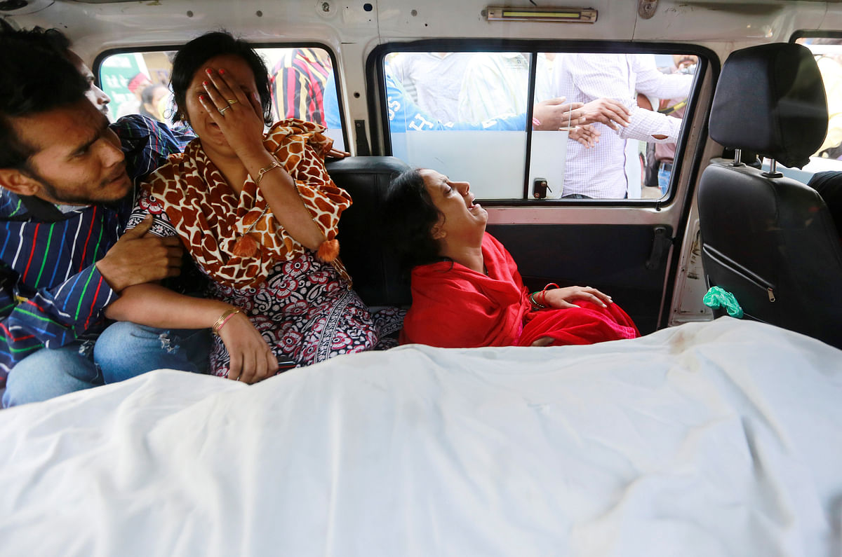 Family members cry as they sit next to the body of their relative after a commuter train travelling at high speed ran through a crowd of people on the railway tracks on Friday, inside an ambulance outside a hospital in Amritsar, India, on 20 October 2018. Photo: Reuters