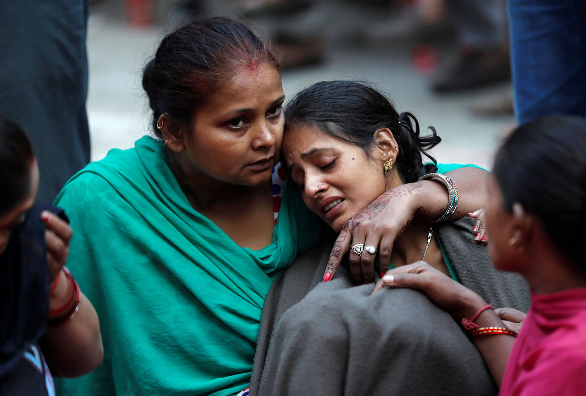 A woman is consoled as she mourns the death of a relative after a commuter train travelling at high speed ran through a crowd of people on the rail tracks on Friday, outside a hospital in Amritsar, India, on 20 October 2018. Photo: Reuters