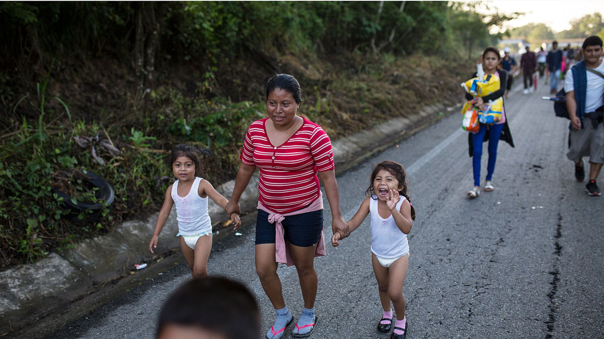 Central American migrant Silvia walks holding onto to her daughters; Karen, 5, left, and Beiyi, 4, with a caravan to the US, make their way to Mapastepec, Mexico, Wednesday, 24 October 2018. Photo: AP