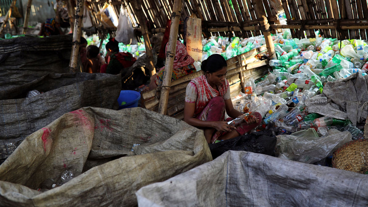 A woman works in a plastic bottle recycling factory in Dhaka, Bangladesh, 21 October 2018. Photo: Reuters