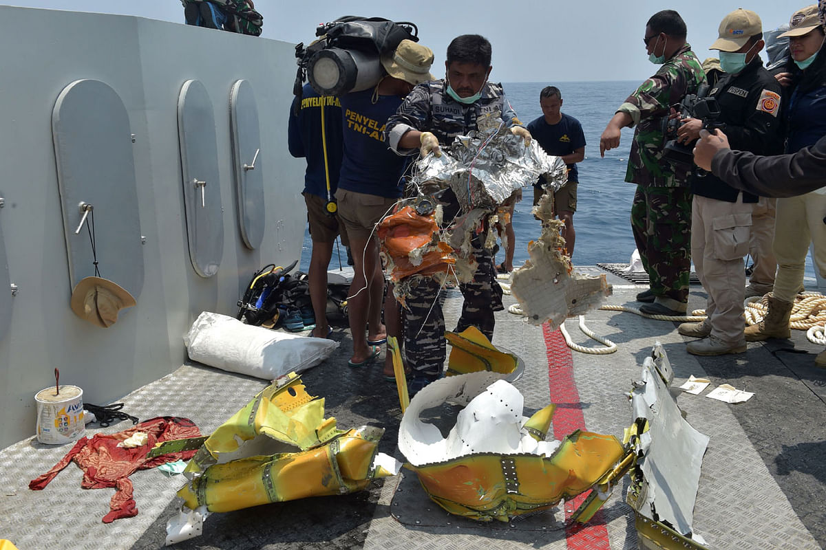 A member of the Indonesian military places parts of the ill-fated Lion Air flight JT 610 onto the deck of the ship during search operations at sea, north of Karawang on 1 November 2018. Photo: AFP