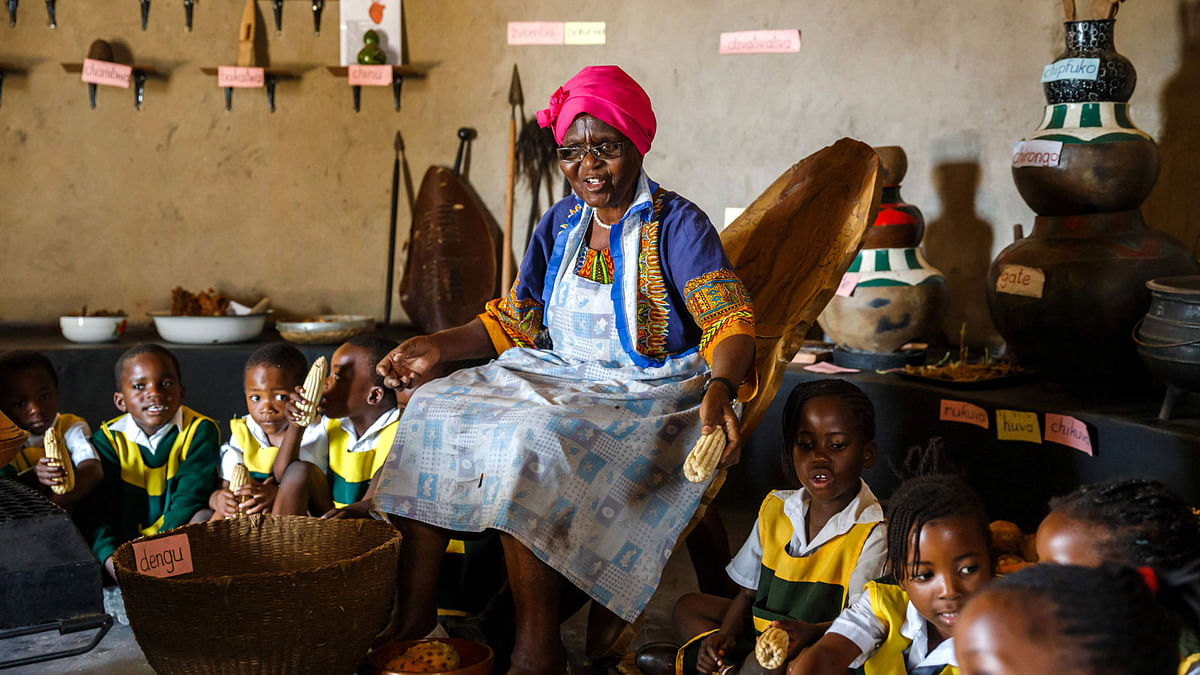 Poet, storyteller and retired schoolteacher, Hatifari Munongi tells a traditional folklore story to a group of kindergarten children visiting the replica traditional homestead she set up in the backyard of her house in the suburb of Marlborough in Harare on 18 October 2018. The replica of a traditional Zimbabwean village is meant to help preserving local culture and share knowledge systems threatened of extinction due to westernisation in urban Zimbabwe. -- Photo: AFP