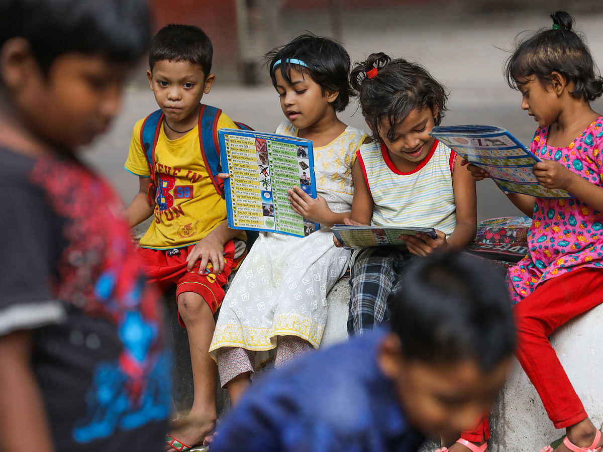 Students of a school for the underprivileged one reading books before their class in Paribagh, Dhaka on 3 November. Photo: Dipu Malaka