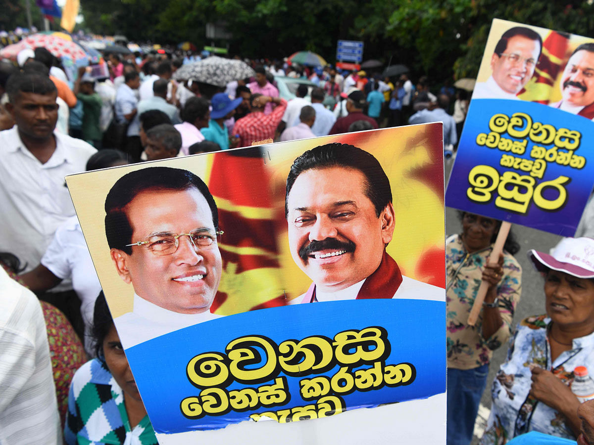 Supporters carry placards with pictures of Sri Lanka`s former president and newly appointed prime minister Mahinda Rajapakse (R) and President Maithripala Sirisena at a rally in Colombo on 5 November 2018. Photo: AFP