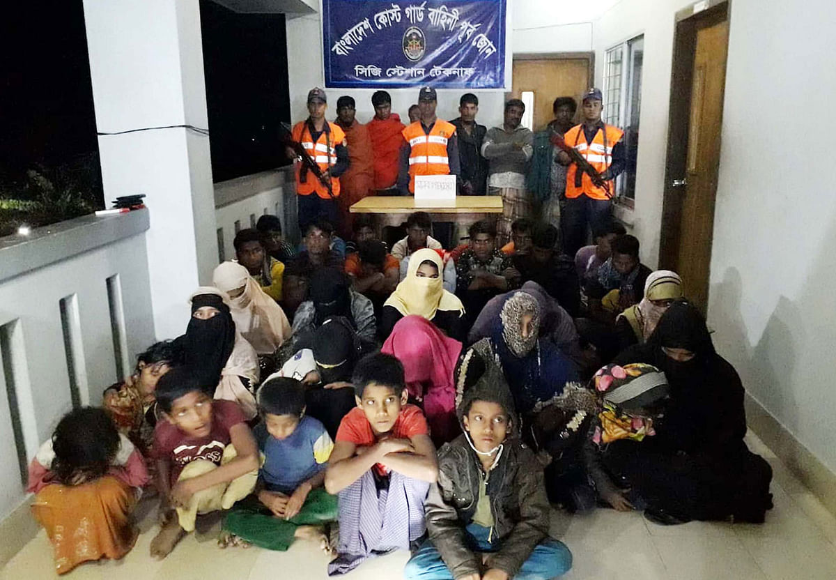 A handout released on 7 November, 2018 by the Bangladesh Coast Guard shows Coast Guard members with Rohingyas and alleged traffickers in Teknaf coast guard station in Bangladesh. Photo: AFP