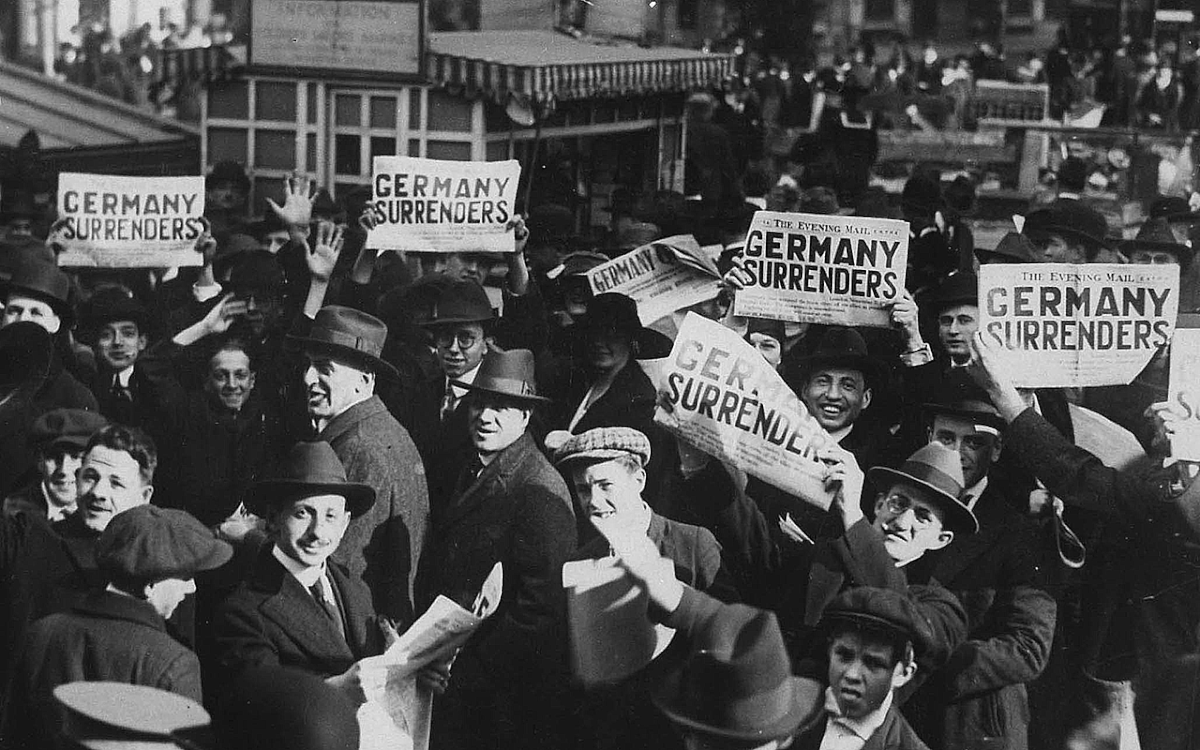 A crowd in Times Square hold up copies of newspapers with a headline about the signing of the Armistice to end World War One, in New York, US on 11 November 1918 US. Photo: Reuters