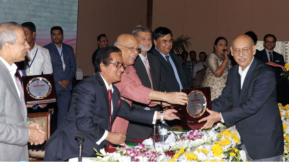 Finance minister AMA Muhith distributes tax cards, crests and certificates to some 202 highest tax payers at national and district level at the Tax Card Giving Ceremony-2018 held at a city hotel on Monday. Photo: PID