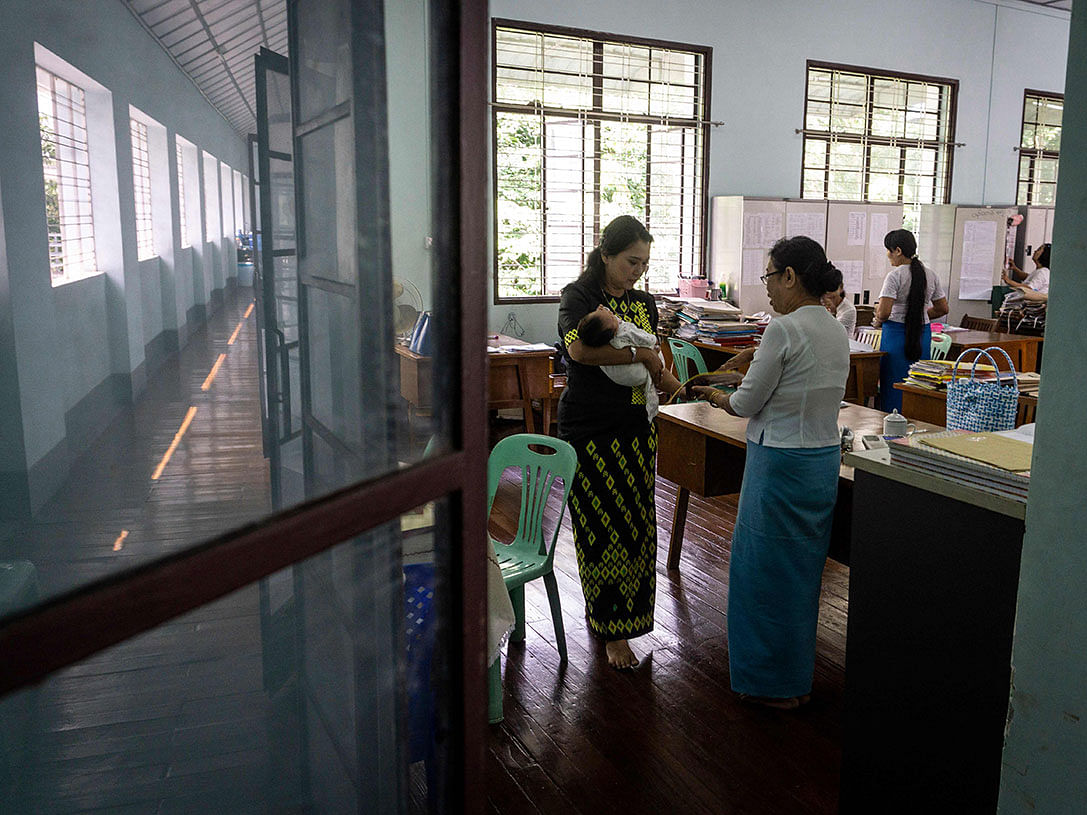 This photo taken on 19 October 2018 shows radiologist Myat Sandar Thant (L) handing over an abandoned baby to an official of the Social Welfare Department in Yangon. Photo: AFP