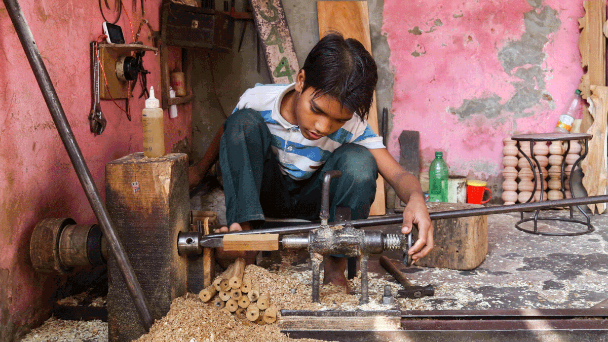 A Bihari child operating a machine to make furniture pieces. Children like him working in such factories are common in the capital. Krishi Market, Mohammadpur, Dhaka, 13 November 2018. Photo: Sabrina Yesmin