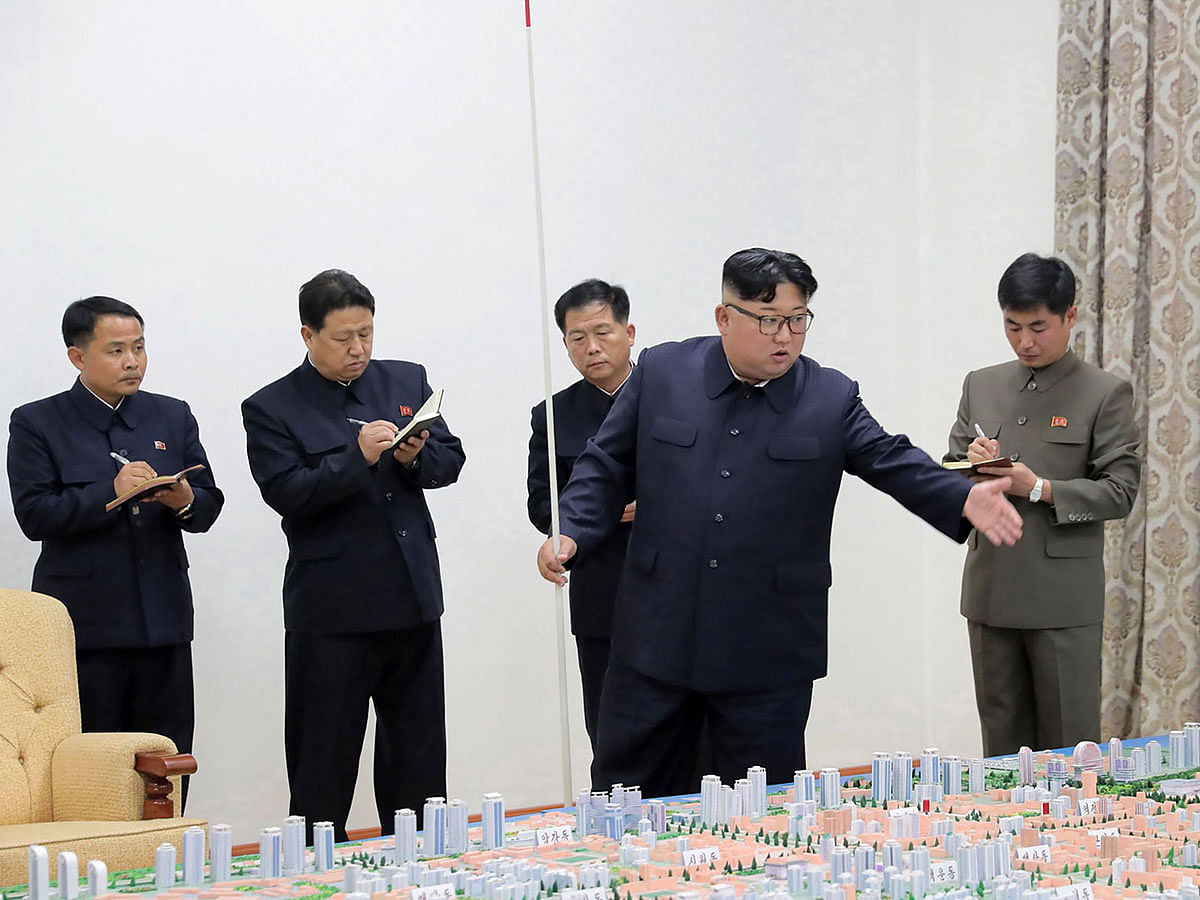 This undated picture released from North Korea`s official Korean Central News Agency (KCNA) on 16 November shows North Korean leader Kim Jong Un (2nd R) examining and guiding the master plan for Sinuiju City at an undisclosed location. Photo: AFP