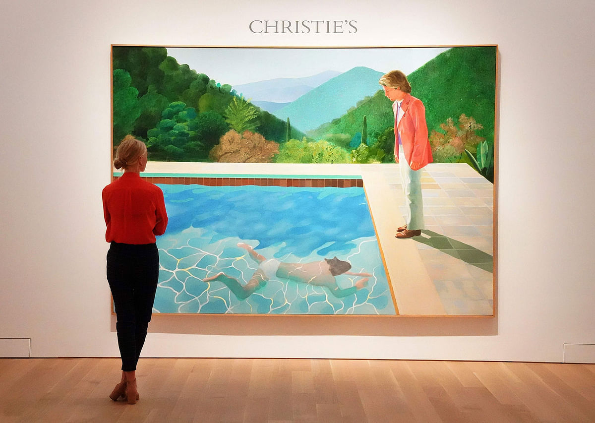 In this file photo taken on 13 September, 2018, a woman looks at David Hockney’s “Portrait of an Artist (Pool with Two Figures)” during a press preview at Christie’s New York. The painting was sold for a whopping $90.3 million on 15 November, breaking a new auction record for a living artist. Photo: AFP