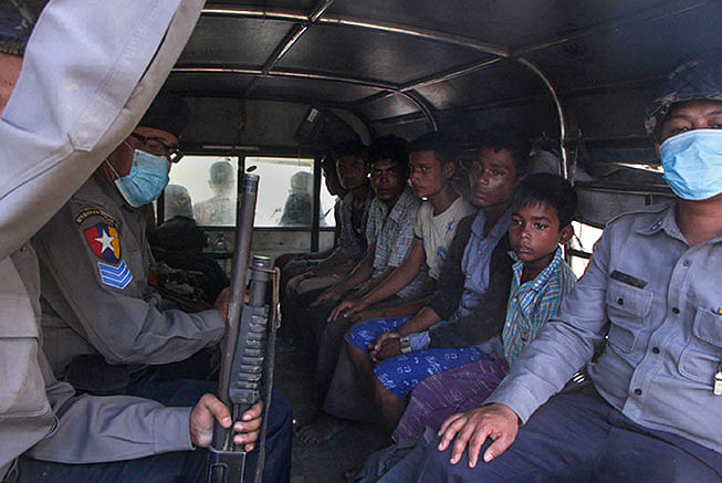 Police escort a group of Rohingya men and boy in Kyauktan township south of Yangon on 16 November 2018 after their boat washed ashore. Photo: AFP