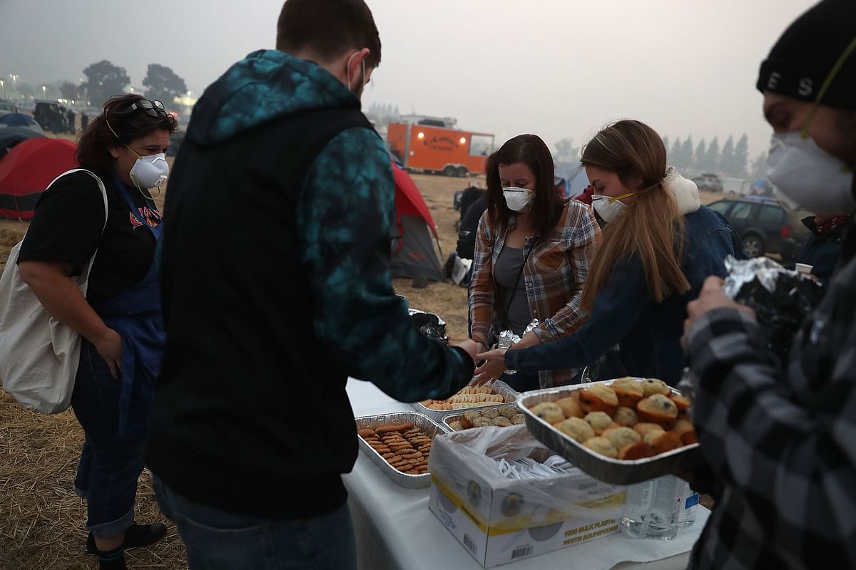 People drop off freshly baked cookies and cupcakes to Camp Fire evacuees who are living in a Walmart parking on 16 November 2018 in Chico, California. Photo: AFP