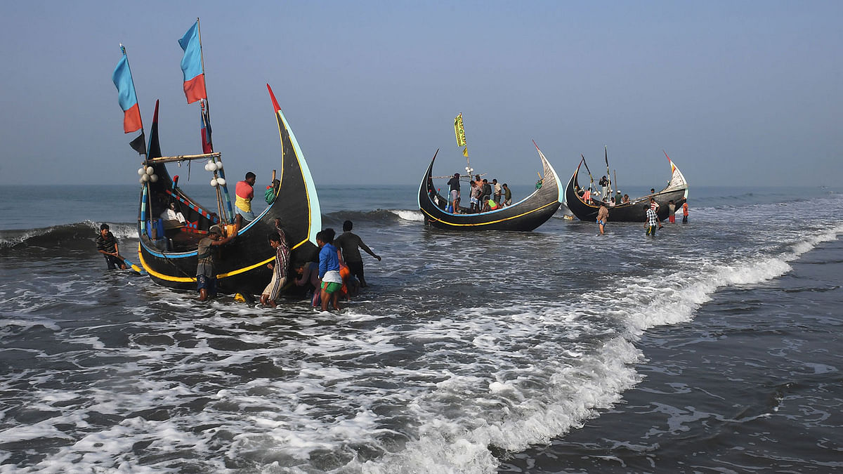 Bangladeshi fishermen unload their catch from fishing boats at Shaplapur fishing village in the Ukhia area of Bangladesh on 17 November, 2018. Photo: AFP