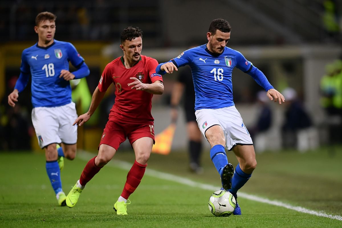 Italy`s defender Alessandro Florenzi (R) holds off Portugal`s defender Mario Rui during the UEFA Nations League group 3 football match Italy vs Portugal at the San Siro Stadium in Milan on 17 November 2018. Photo: AFP
