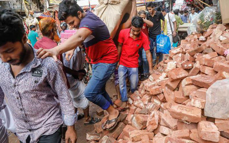 Bricks are piled on road. Pedestrians face difficulty as they pass by. Chawkbazar, Dhaka, 4 June. Photo: Dipu Malakar