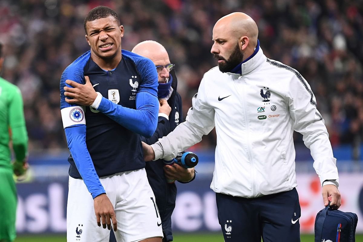 France`s midfielder Kylian Mbappe (L) leaves the pitch after getting injured during the friendly football match France vs Uruguay, on November 20, 2018 at the Stade de France in Saint-Denis, outside Paris. / AFP