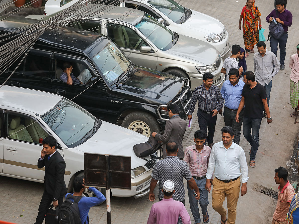 Pedestrians suffer due to the cars parked on the pavements unlawfully at Dhanmondi-15 along Sat Masjid Road in Dhaka on 20 November. Photo: Dipu Malakar