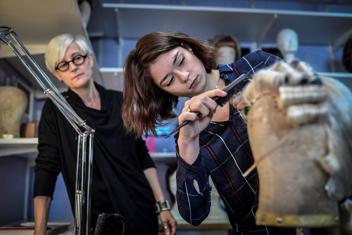 Academy pupil in wigmaking Camille Laurent (R) trains with her tutor Clothilde Loosveldt on 6 November 2018 at the Opera Bastille in Paris. An academy created in 2015 at the Paris Opera welcomes some 40 apprentices each year to learn the crafts of costume and wig making, tapistry, singing and music. Photo: AFP
