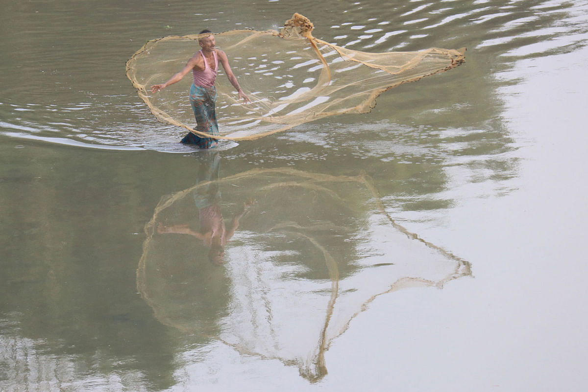 A fisherman casting his net standing in shallow water caused by the winter at the river Chengi in Nicher Bazar, Khagrachhari on 24 November. Photo: Nerob Chowdhury