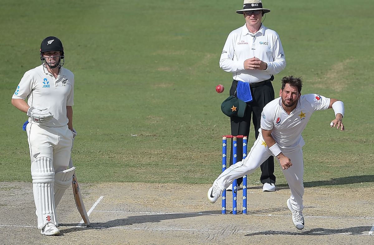 Pakistani spinner Yasir Shah (R) delivers the ball as New Zealand batsman Henry Nicholls (L) looks on during the fourth day of the second Test cricket match between Pakistan and New Zealand at the Dubai International Stadium in Dubai on 27 November 2018. Photo: AFP